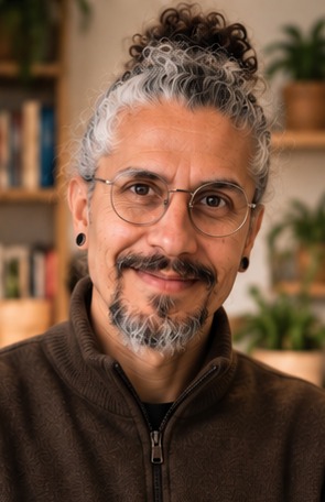 Carlos Iván i brun tröja framför en bokhylla